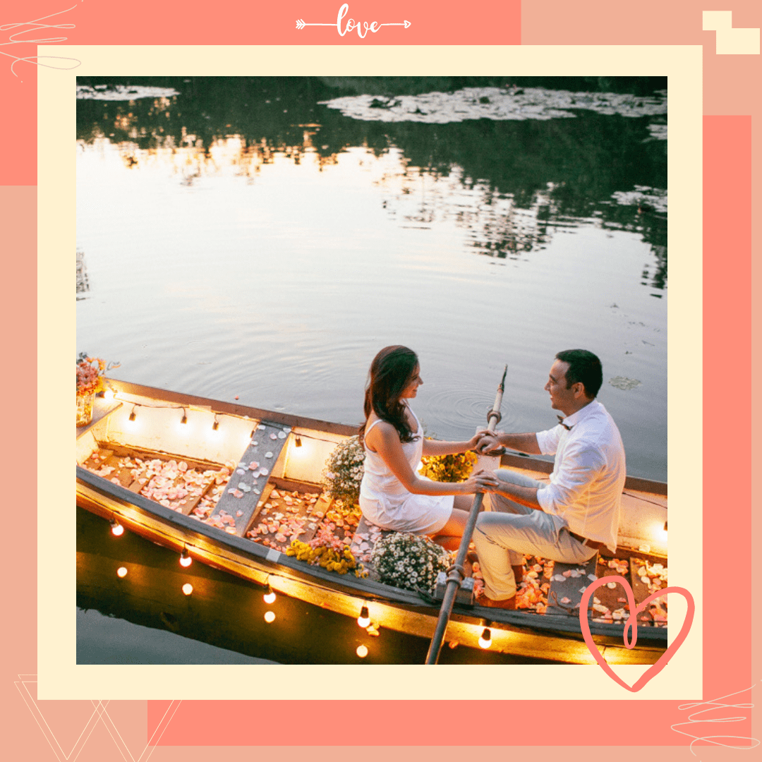 casal dentro de um barco com pétalas de rosas e luzes no rio 