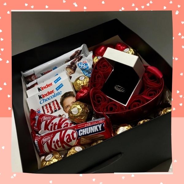 caixa com chocolates, rosas e aliança de namoro