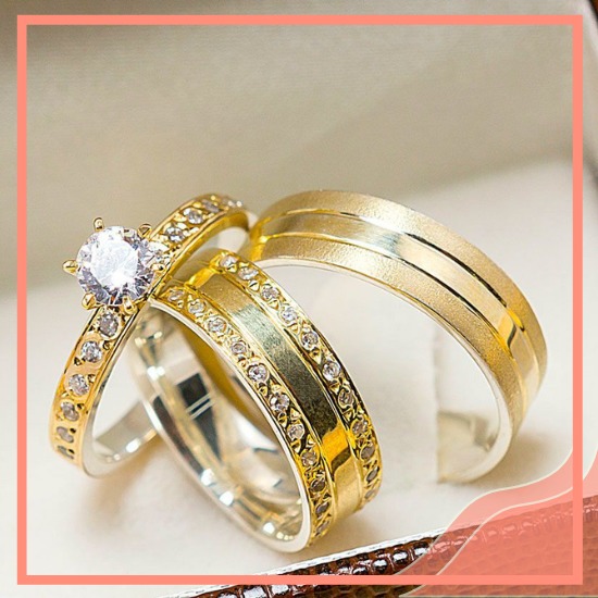 par de alianças de noivado douradas com anel solitario cheio de pedras