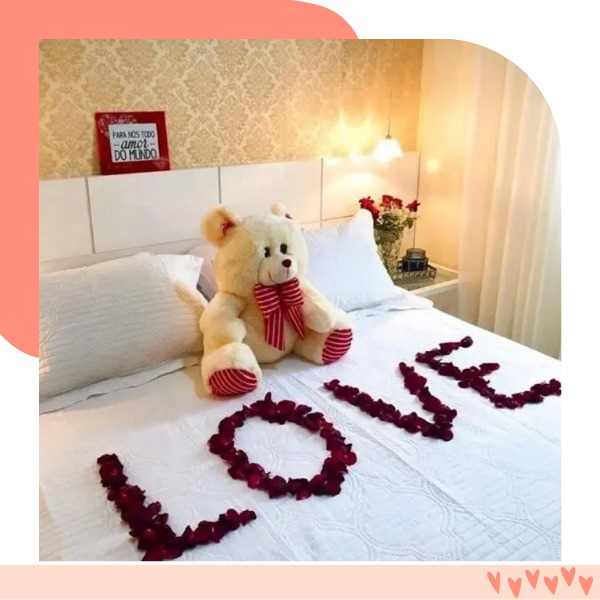 urso em cima da cama e petalas de rosas escrito love