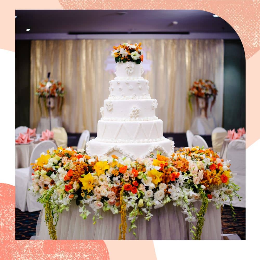 bolo de casamento grande em mesa com flores