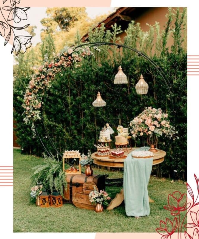mesa de doces no jardim com arco de flores